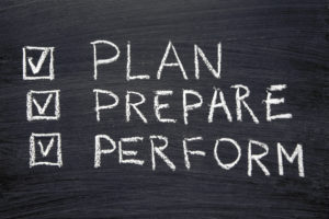 plan, prepare, perform words handwritten on chalkboard with marked check-boxes