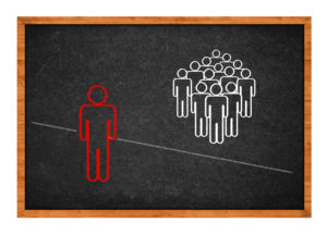 Simple conceptual drawing on school blackboard - man expelled from the group, unable to cross the line that separates them.