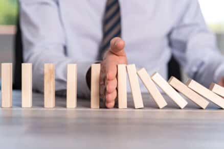 Sales Mindset Focus on What’s in Your Control blog and businessman stopping falling dominoes.