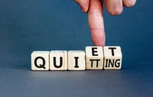 Quiet Quitting in Sales? Not a Real Thing blog and finger tipping over quiet quitting sign.